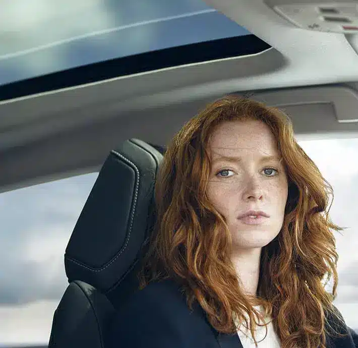 jeune femme rousse qui regarde face à l'objectif jdans vehicule berline Citroën disponible chez Citroën Valréas